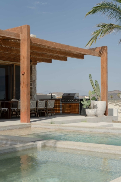 A Stone Covered Home That Surrounds A Central Courtyard With Sunken Seating