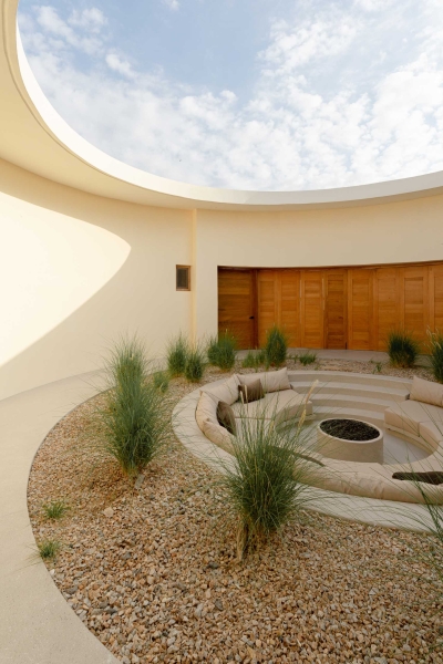 A Stone Covered Home That Surrounds A Central Courtyard With Sunken Seating