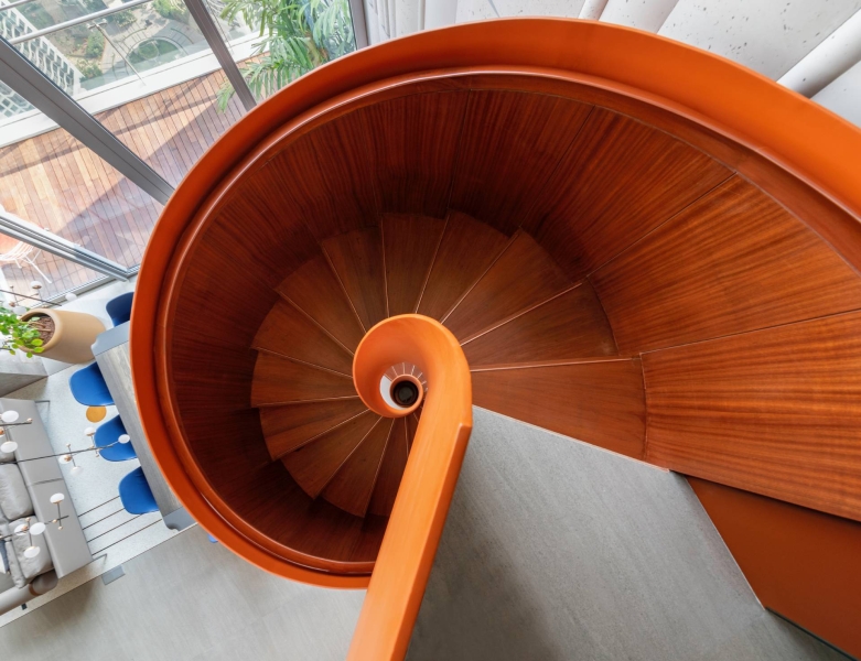 An Orange Spiral Staircase Is An Eye-Catching Feature Inside This Apartment