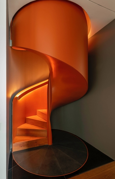 An Orange Spiral Staircase Is An Eye-Catching Feature Inside This Apartment