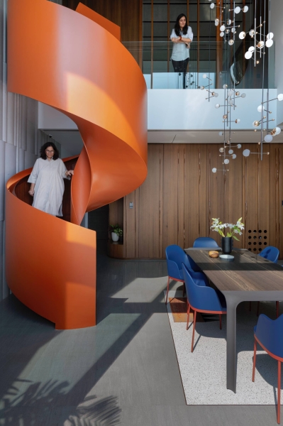 An Orange Spiral Staircase Is An Eye-Catching Feature Inside This Apartment