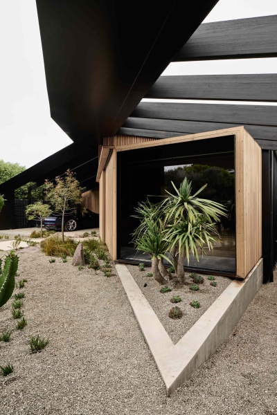 A beachside boardwalk reimagined as the spine of a modern home