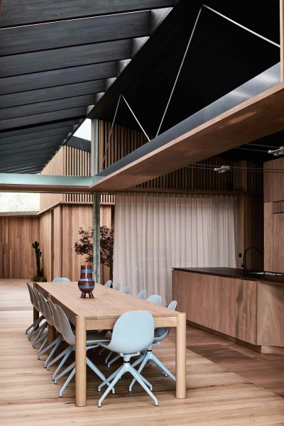A beachside boardwalk reimagined as the spine of a modern home