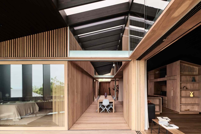 A beachside boardwalk reimagined as the spine of a modern home