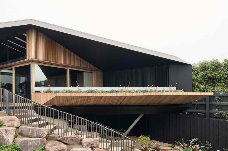 A beachside boardwalk reimagined as the spine of a modern home