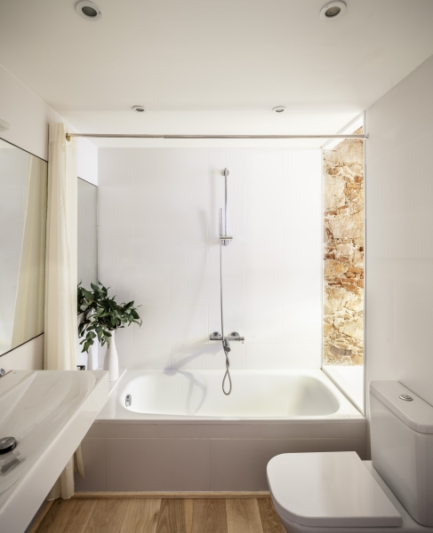 A Rustic Stone Wall Meets Sleek Minimalism in This Apartment