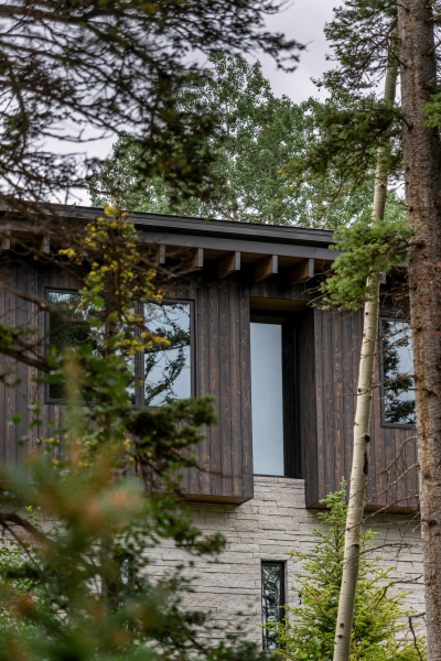 From the outside this home is all blackened wood, but inside it glows with warmth