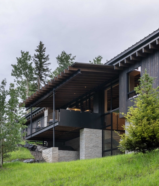 From the outside this home is all blackened wood, but inside it glows with warmth