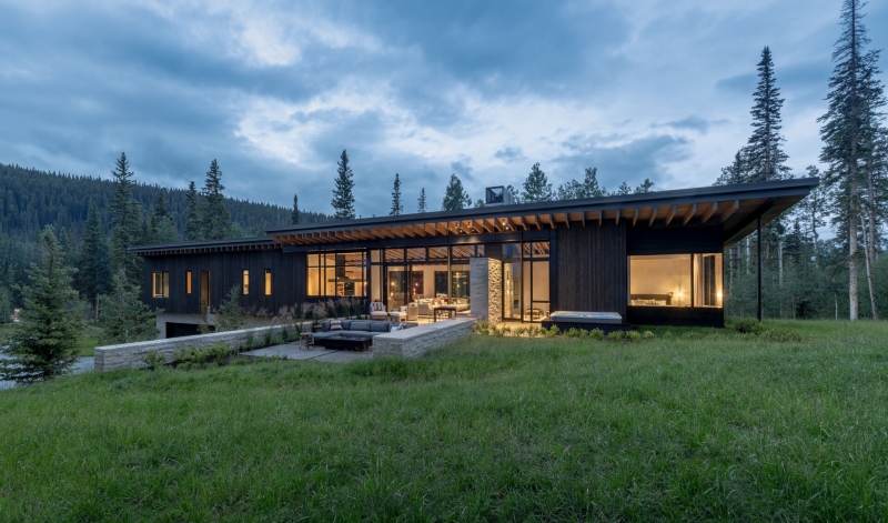 From the outside this home is all blackened wood, but inside it glows with warmth