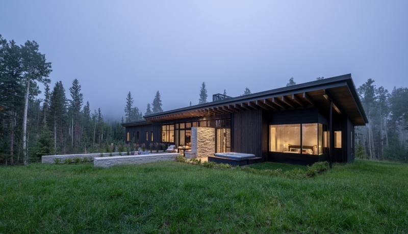 From the outside this home is all blackened wood, but inside it glows with warmth