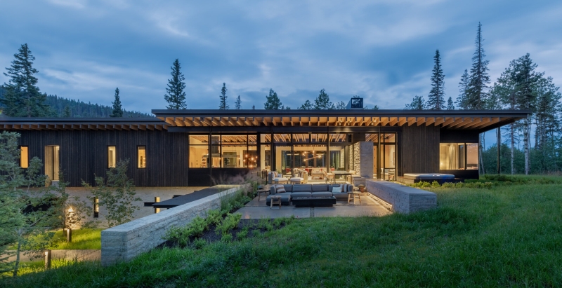 From the outside this home is all blackened wood, but inside it glows with warmth