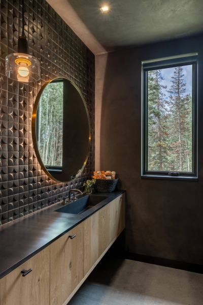 From the outside this home is all blackened wood, but inside it glows with warmth