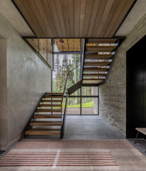 From the outside this home is all blackened wood, but inside it glows with warmth