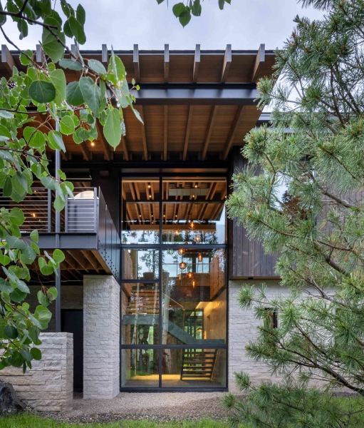 From the outside this home is all blackened wood, but inside it glows with warmth