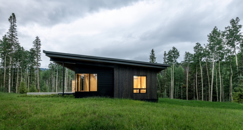 From the outside this home is all blackened wood, but inside it glows with warmth