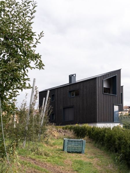 A Bold Black House Rises From a Landscape of Orchards