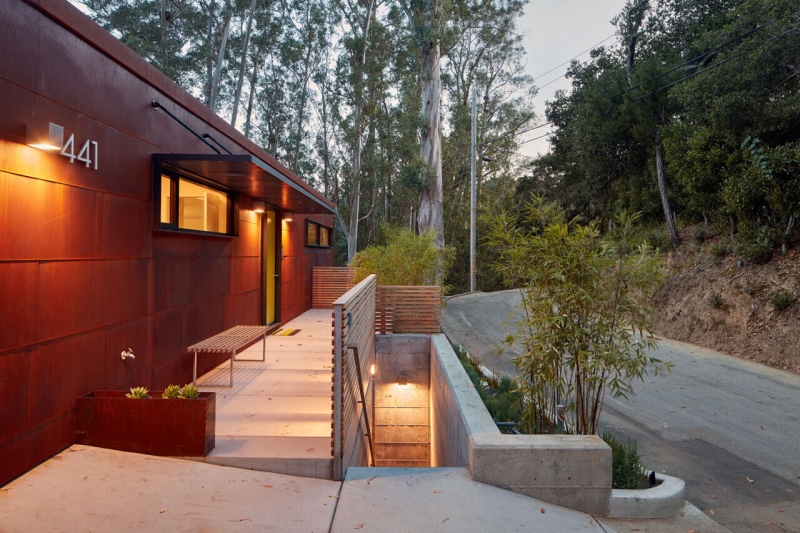 The Hillside House Wrapped in Rusted Steel with a Bright Yellow Surprise