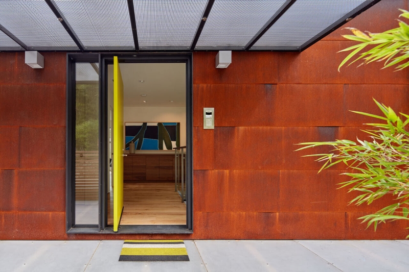 The Hillside House Wrapped in Rusted Steel with a Bright Yellow Surprise